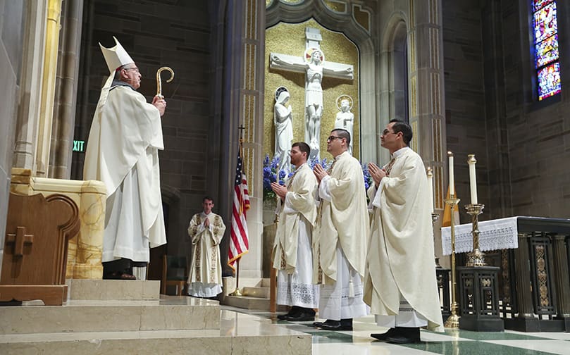 As the June 27 priesthood ordination draws to an end and just before they leave the cathedral to the recessional song, “Holy God We Praise Thy Name,” the Archdiocese of Atlanta’s newest priests, (r-l) Father Miller Gómez Ruiz, Father Cristian Cossio and Father Paul Porter, stand before Archbishop Gregory J. Hartmayer, OFM Conv., during the closing prayer and final blessing. Photo By Michael Alexander