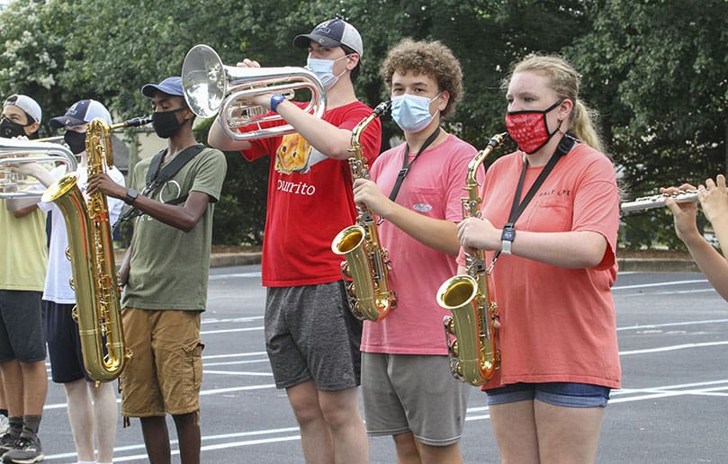 Twenty brass and wind musicians in the St. Pius X High School marching band practice during the final day of band camp, July 30, in a parking lot on the Atlanta campus. Some of the students included, left to right, senior Jack Caffrey (trombone), sophomore Luke Lyon (flugelhorn), junior Devin Smith (baritone sax), senior Ryan Law (flugelhorn), junior Joshua Bartholomai (alto sax), and sophomore Chandler Panarese (alto sax). Photo By Michael Alexander