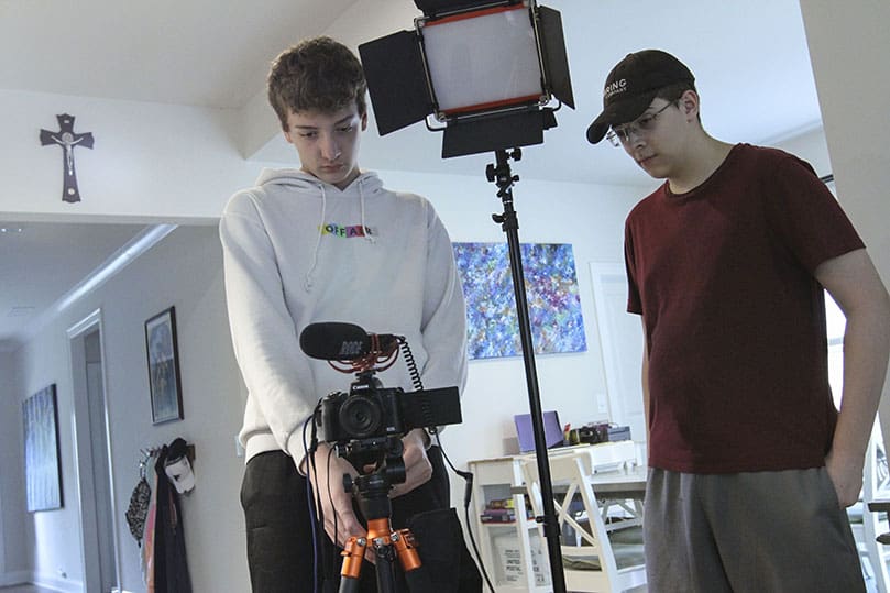 Sixteen-year-old Tommy, left, and 18-year-old Ben were hired by their parents to set up all the equipment and lights for the rosary livestream and the recording of the weekly podcast. Photo By Michael Alexander