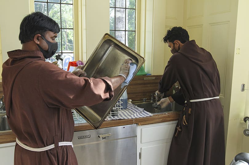 On a Wednesday morning, in the kitchen at St. John’s Lutheran Church, Atlanta, Brother Praveen Turaka, OFM Cap., left, dries the dishes and Brother Robert Perez, OFM Cap., washes them. In addition to kitchen duties, they assist Mercy Community Church with feeding the “Intown Atlanta” community outdoors on the St. John’s Lutheran Church grounds. Photo By Michael Alexander