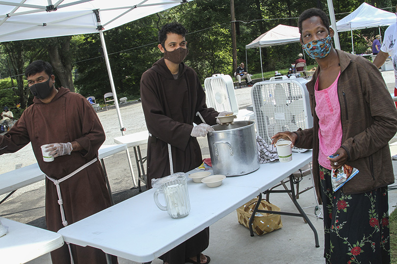Serving mountain mint tea, lemonade or coffee and vegetable soup was one of the jobs Capuchin Franciscan Friars Brother Praveen Turaka, left, and Brother Robert Perez, center, did August 19, when they were helping with a community fellowship lunch in Atlanta, just east of Midtown. Brother Robert, 38, and Brother Praveen, 37, came to Atlanta, June 23, from Florida and New York, respectively. Photo By Michael Alexander