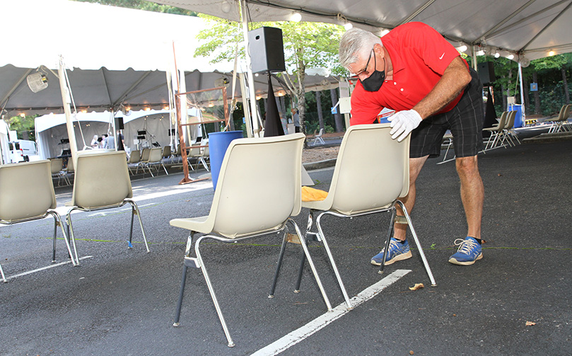John Doolen, director of operations at St. Thomas Aquinas Church, Alpharetta, disinfects and cleans the chairs between Masses. Photo By Michael Alexander
