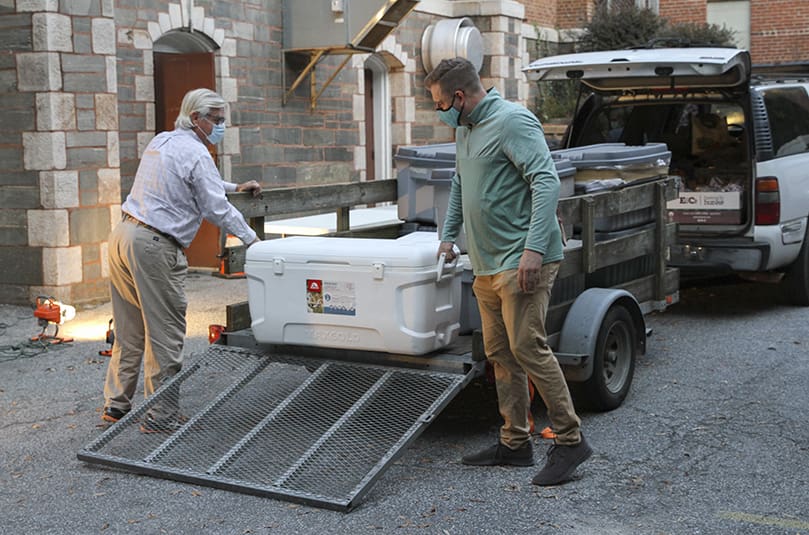 Dan Stephens, left, a volunteer from Peachtree City United Methodist Church, and Cathal Doyle, co-manager of the Central Night Shelter at the Shrine of the Immaculate Conception, Atlanta, unload some of the hot meals for the evening of Nov. 6. Photo By Michael Alexander