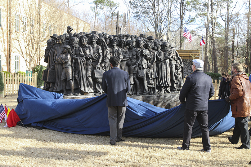 Members of the unveiling delegation remove the covering from the “Angels Unawares” sculpture during a ceremony on Jan. 7. The sculpture is available for viewing by the public from 9 a.m. until 9 p.m. Monday through Saturday, and from 2 p.m. until 9 p.m. on Sunday. Photo By Michael Alexander