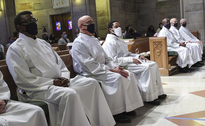 Deacon candidates (foreground to background) Carl Taylor, Chris Waken, Avery Daniel, Dr. Henry Ohaya, David Stenzel and Orlando Caicedo listen to Archbishop Gregory J. Hartmayer's homily during their diaconate ordination. John Campbell was the seventh candidate out of the camera's view. Photo By Michael Alexander