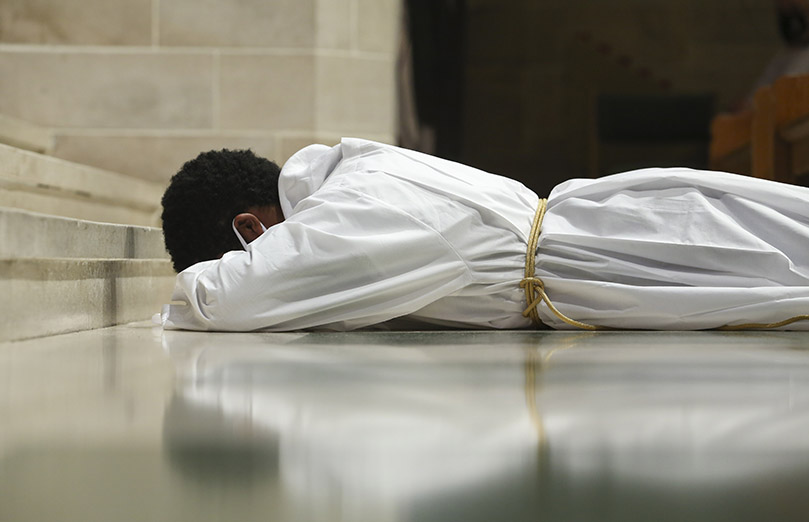 During the invitation to prayer, 28-year-old Avery Daniel, a transitional deacon candidate, prostrates himself before altar at the Cathedral of Christ the King, Atlanta. Daniel was ordained with six permanent deacon candidates. Photo By Michael Alexander