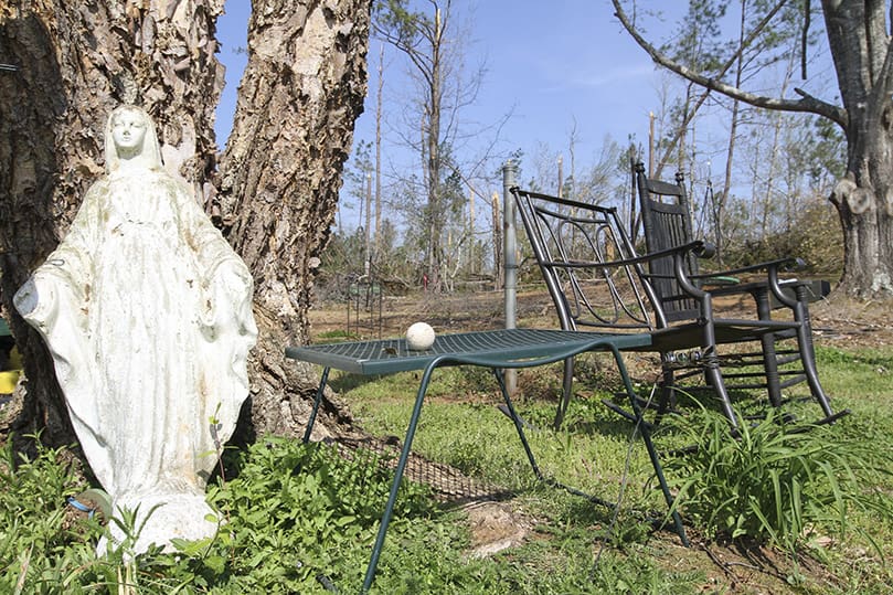A statue of the Virgin Mary leans up against a tree in the backyard of the Garza home. Before the tornado, it rested among some vines in a garden arbor. The statue originally belonged to Alex Garza’s mother, but they brought it up from Columbus after she died. Photo By Michael Alexander