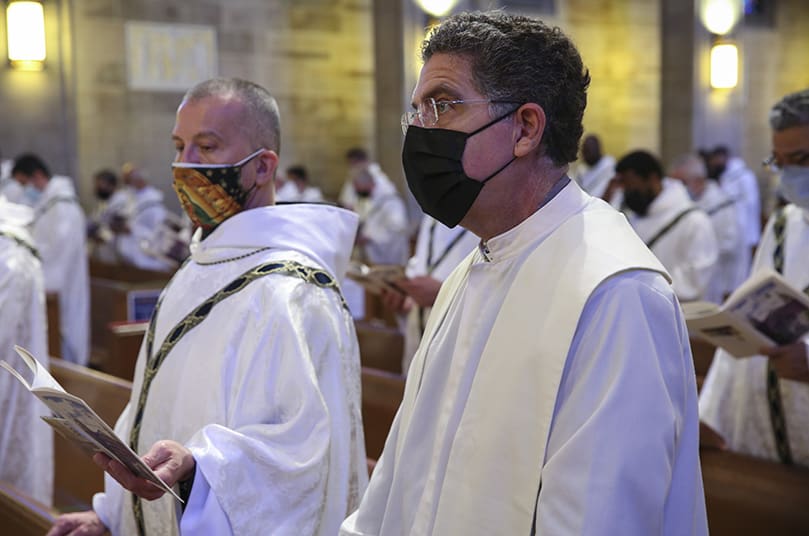 Father Rafael Carballo, right, pastor of St. Mary Church, Rome, and Father Santo Cricchio, OFM, Conv., of St. Philip Benizi Church, Jonesboro, join fellow clergy in the renewal of their priestly commitment during the March 30 Chrism Mass. Photo By Michael Alexander