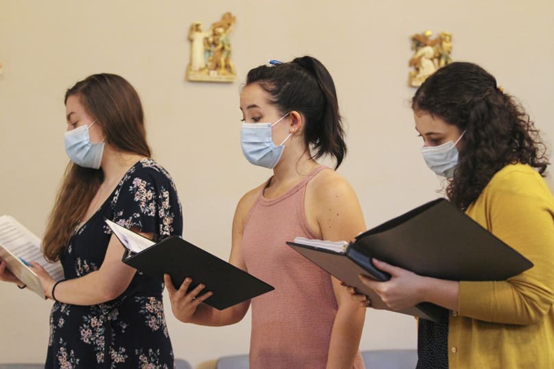 (L-r) Cristina Dinella, Anna Julia Gowasack and Alex Matlack attend Wednesday evening rehearsal for the Concordi Laetitia Choir at the Georgia Tech Catholic Center chapel. Dinella is a graduate of the Eastman School of Music, Rochester, N.Y. Gowasack was a member of two choral ensembles, the Schola Corvorum and the St. Scholastica Singers, at her alma mater Benedictine College, Atchison, Kan. Matlack, a graduate of Georgia Tech, was a member of the school’s Chamber Choir. Photo By Michael Alexander