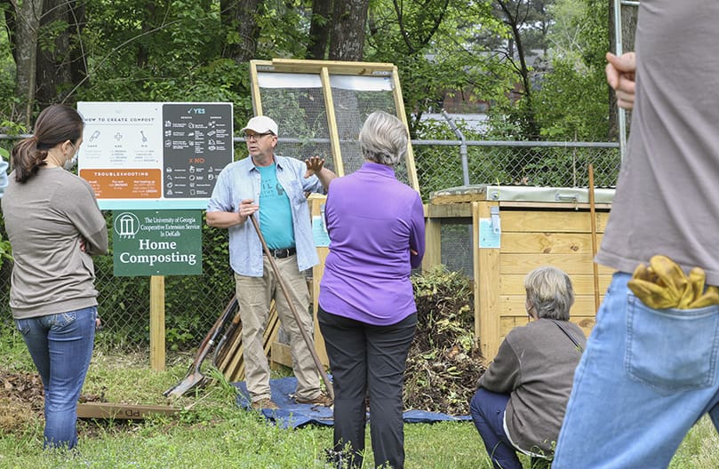 Fred Conrad, background, white cap, senior manager of community gardens at Food Well Alliance, Atlanta, conducts a demonstration on composting for new and existing gardeners at the Stone Mountain Community Garden. Photo By Michael Alexander