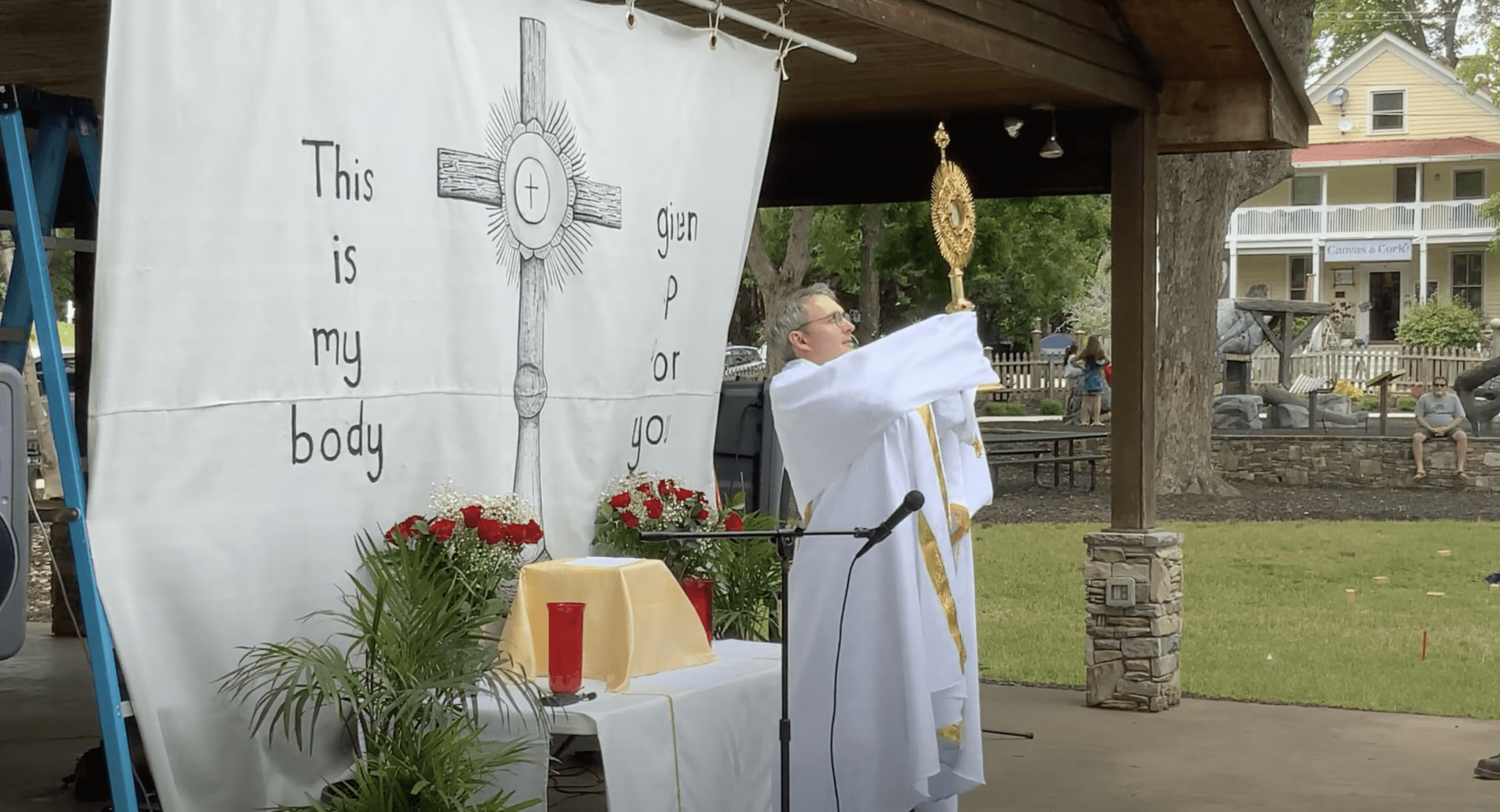 Father Matthew Dalrymple, parish administrator at St. Luke Church, Dahlonega, blesses the congregation with the Eucharist in the monstrance.