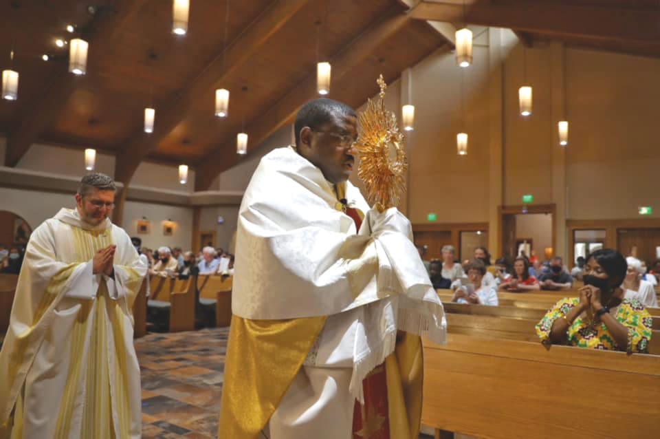 Father Henry Atem, pastor of St. Lawrence Church leads a eucharistic procession at the Lawrenceville parish June 5. He is a member of the archdiocese’s eucharistic renewal steering committee.Photo courtesy St. Lawrence Church