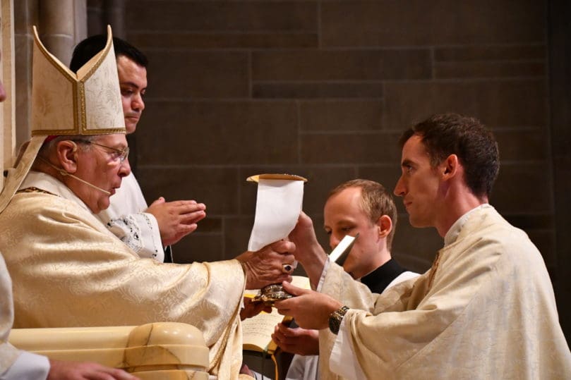 Archbishop Gregory John Hartmayer, OFM Conv., presents the chalice and paten to new priest Father Paul Nacey. The archbishop ordained two new priests at the Cathedral of Christ the King, Atlanta, June 12. Photo by Jackie Holcombe