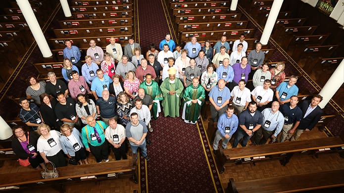 Over 60 attendees with the Diocesan Information Systems Conference (DISC), representing 14 archdioceses and 34 dioceses, pose with vested clergy (center, l-r) Deacon Marino Gonzalez, Archbishop Wilton D. Gregory and Father Roderick Vonhogen of the Archdiocese of Utrecht in the Netherlands, at Sacred Heart of Jesus Basilica, Atlanta. They were in town for the 32nd annual DISC assemblage at the JW Marriott Buckhead, June 22-25. Photo By Michael Alexander