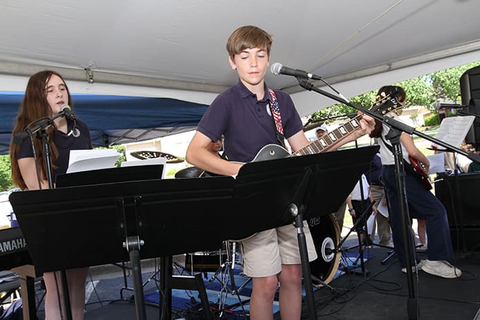 St. Catherine of Siena School praise band members included eighth-grader Charlie Smith, center, on guitar, seventh-grader Samantha Gregory on keyboards, left, her sister Sarah on bass, right, and William Collins on drums. They performed for various students under a tent on the school parking lot during the Faith Rally. Photo By Michael Alexander