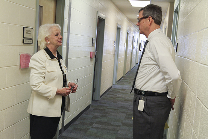 Blessed Trinity High School assistant principal Susan Dorner, left, catches up with principal Frank Moore in the hall to apprise him of a school matter before he heads off to his next morning activity. Photo By Michael Alexander