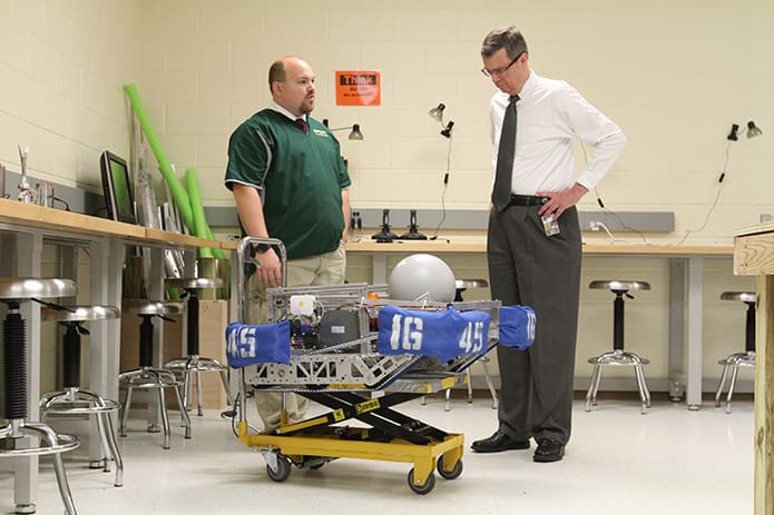 As Blessed Trinity High School principal Frank Moore walks the building one April morning, he stops by Brent Hollers’ robotics lab, where Hollers offers an explanation about the robot that was used by the competition robotics team during the state championship held at the University of Georgia April 14-16. Photo By Michael Alexander