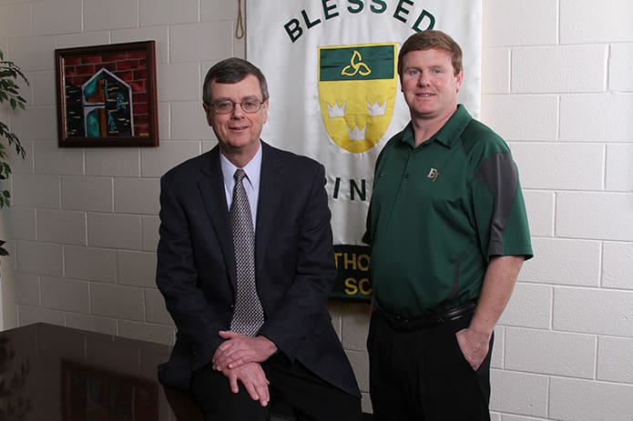 In 2000 Frank Moore, left, became the founding principal at Blessed Trinity High School, Roswell, and Ricky Turner became its founding athletic director. Moore, who will retire at the conclusion of the 2015-2016 school year, typically meets with Turner every morning to get an update on the school’s athletic activities. Photo By Michael Alexander