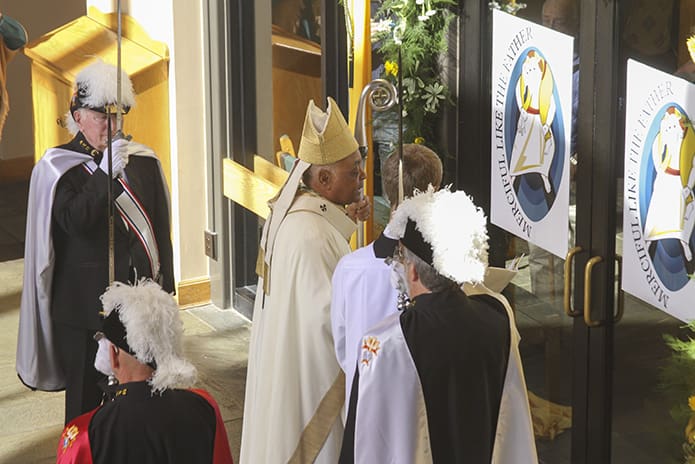 Standing among members of the Knights of Columbus, Father Emmeran Bliemel O.S.B., Assembly 1962 honor guard, Archbishop Wilton D. Gregory conducts the rite for the opening of the Holy Door of Mercy at St. Philip Benizi Church in Jonesboro. Photo by Michael Alexander