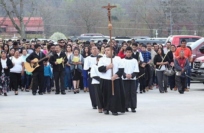 Thirteen-year-old Ricky Gomez, holding the procession cross, leads the Palm Sunday procession from the lower parking lot of St. Paul the Apostle Church, Cleveland, to the sanctuary. Photo By Michael Alexander