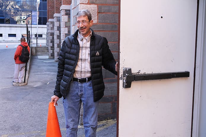 In this 2014 photo Mark Bashor holds the door open at the Shrine of the Immaculate Conception as volunteers unload food and supplies for the evening meal at the night shelter. After serving a number of years as shelter director, Bashor stepped down in 2000, and his wife Katie assumed the role. Photo By Michael Alexander
