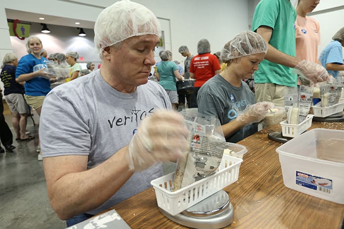 Dave Lemcoe of St. Brigid Church, Johns Creek, weighs the meal bags to ensure they fall between 389 and 394 grams. Lemcoe was one of the 300 people participating in the second of two June 3 shifts for Starve Wars at the Georgia International Convention Center, College Park. Photo By Michael Alexander