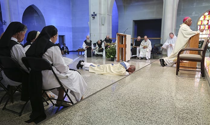 During the invitation to prayer Abbot-elect Augustine Myslinski, OCSO, prostrates himself before the Lord on the sanctuary floor of the monastery as the cantors lead the congregation in singing the Litany of Saints. Photo By Michael Alexander