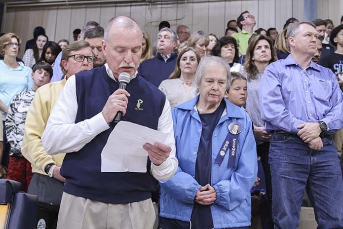 St. Pius X athletic director, Mark Kelly, holds the microphone as he leads a prayer before the Dec. 20 varsity boys basketball game against Eagle's Landing High School of McDonough. Photo By Michael Alexander