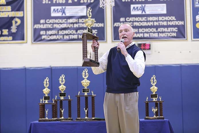 St. Pius X athletic director, Mark Kelly, prepares to present the winner’s trophy, Dec. 30, to John Carroll School of Bel Air, Md., following a 73-65 championship game victory over St. Pius X during the 18th annual St. Pius X Christmas Classic, a three-day basketball tournament featuring 16 teams from eight states. Photo By Michael Alexander