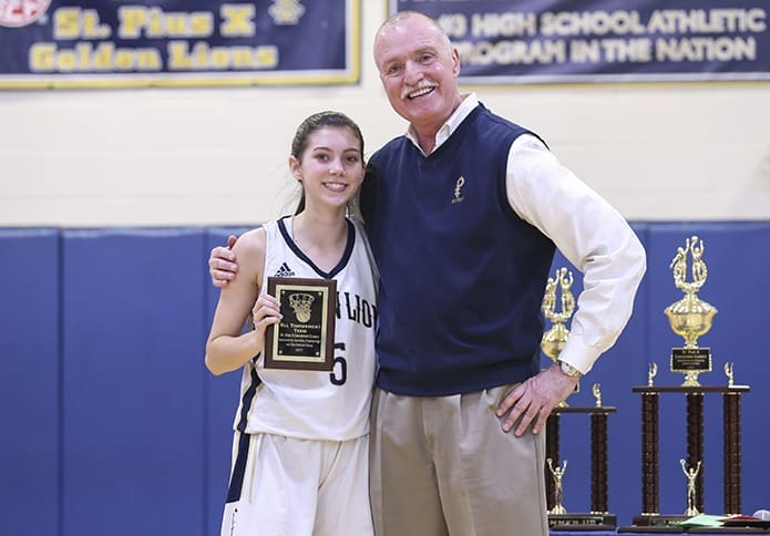 St. Pius X athletic director, Mark Kelly, right, poses for a photo after presenting an All-Tournament Team plaque to St. Pius X junior shooting guard, Emma Drash. Kelly’s final task before officially retiring was handing out tournament trophies and plaques, after the Dec. 30 girls and boys championship games of the 18th annual St. Pius X Christmas Classic. Photo By Michael Alexander