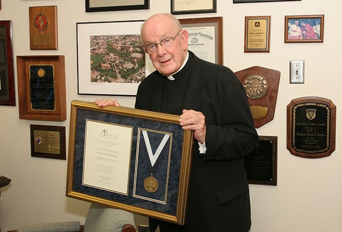 In this Sept. 2008 photo Msgr. R. Donald Kiernan, pastor of All Saints Church, Dunwoody, holds the Bicentennial Medal from Mount St. Mary’s University he received during the school’s Bicentennial Atlanta Celebration at The Buckhead Club. Msgr. Kiernan was chosen from a select group of individuals and organizations from throughout the United States “whose work has characterized the University’s commitment for excellence in building communities in service to others.” The 200-year-old Emmitsburg, Md., institution is the second oldest independent Catholic college in the United States.