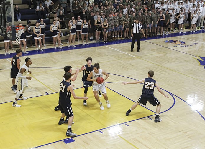 St. Pius X senior guard Carson Seramur (with ball) draws a crowd from three Marist School defenders as he penetrates the paint area on the court. Seramur was his team’s leading scorer with 12 points. Photo By Michael Alexander