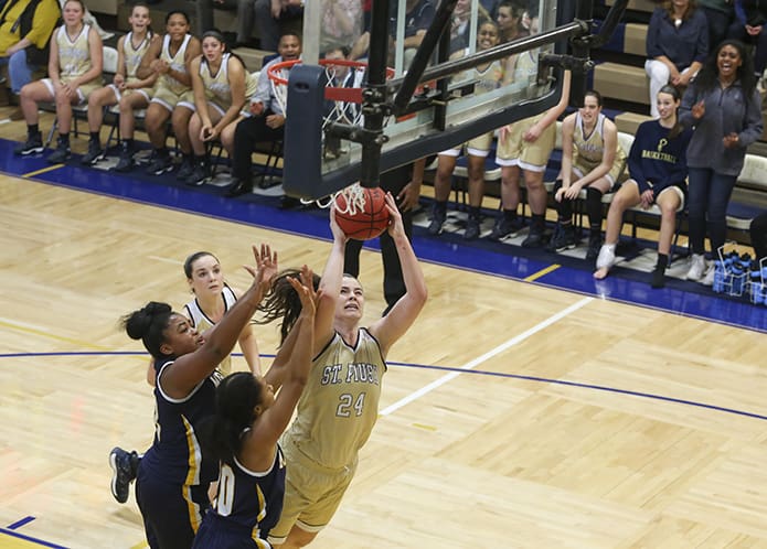Macey Carson (#24), a junior post player for St. Pius X, takes it up over two Marist School defenders. Carson only had four points, but she also had three rebounds, two assists and three blocked shots. St. Pius defeated Marist 43-26 in the Dec. 6 game. Photo By Michael Alexander