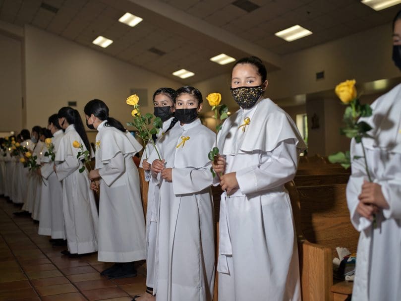 Altar servers hold yellow roses as they await the processional with Bishop-designate Jacques E. Fabre-Jeune, CS, at San Felipe de Jesús Mission. Photo by Johnathon Kelso