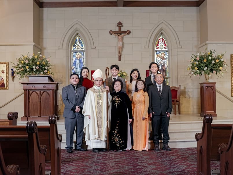 Bishop John Nhan Tran and his family gathered for an ordination day photo in the chapel of St. Peter Chanel Church. Photo by Johnathon Kelso