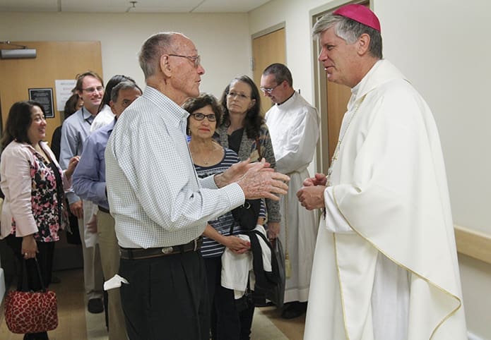 Bishop Ned Shlesinger greets Mass attendees as they leave the chapel at the Atlanta Veterans Administration Medical Center. Here he converses with Bob Jones, a veteran, a hospital volunteer and a member of Holy Cross Church, Atlanta. Photo By Michael Alexander