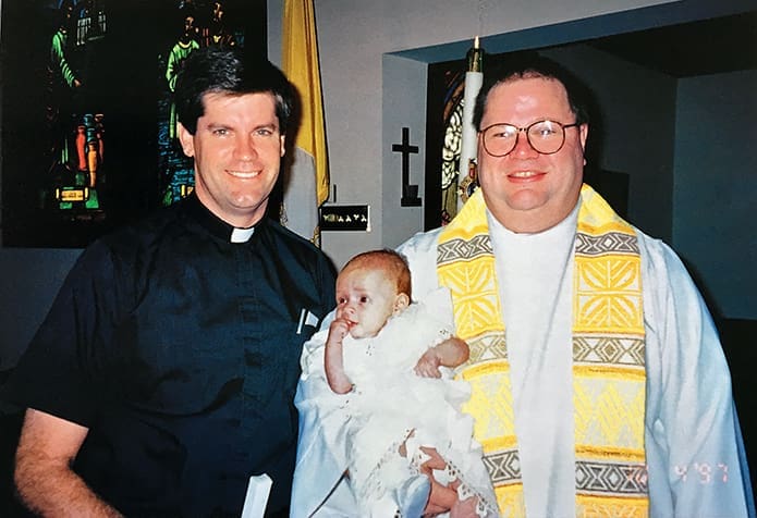 Father Bernard E. (Ned) Shlesinger III served in the role of godfather during James Giddens’ Oct. 4, 1997 baptism at Our Lady of Guadalupe Church in Newton Grove, N.C. Standing to the right is Father Joseph J. Yaeger, Our Lady of Guadalupe Church pastor at the time. James is the first-born son of Janice and Wade Giddens. Father Shlesinger officiated the couple’s 1996 wedding at the same church. Photo Courtesy of Wade and Janice Giddens