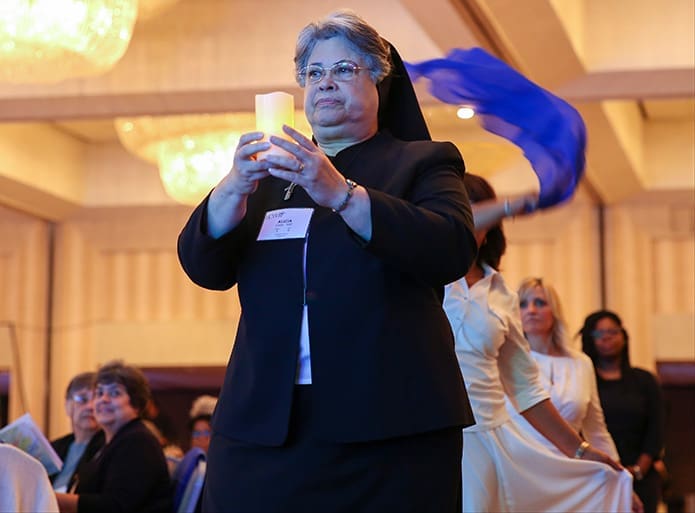 Sisters of the Holy Family Alicia Costa of New Orleans, La., leads a procession into the ballroom, followed by liturgical dancers, to open the morning session of the Leadership Conference of Women Religious in Atlanta August 12. Photo By Michael Alexander