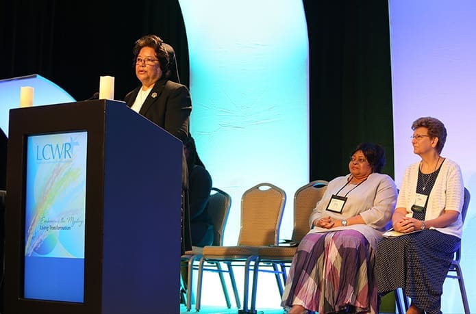 Sisters of the Holy Family Greta Jupiter, regional host for the LCWR, prepares to introduce the morning speaker, Dr. Shannen Dee Williams, an assistant professor in the department of history at the University of Tennessee, Knoxville. Dr. Williams gave a presentation on “Racism and U.S. Religious Life. Sitting on the stage are Daughters of the Heart of Mary Sister Anita Baird, left, and Sisters of the Providence of Saint Mary of the Woods (Ind.) Dawn Tomaszewski, who offered their own response following the speaker’s talk. Photo By Michael Alexander