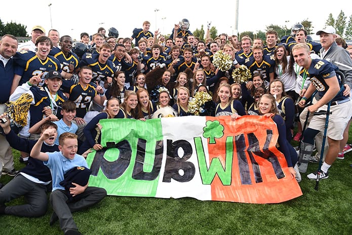 The Marist School football team celebrates a “Dub-Win” after its 27-0 victory over Belen Jesuit Preparatory School of Miami, Fla., at the American Football Showcase in Dublin, Ireland. The team was joined by some of the Irish students, bottom left, who attend the Marist schools in Ireland visited by the Atlanta students during their trip abroad. Photo By Cody Glenn/SPORTSFILE