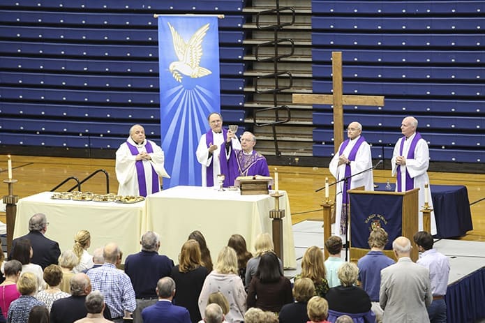 Bishop-designate Joel M. Konzen, SM, elevates the chalice during the consecration of the March 18 Family Mass in his honor. Joining him on the altar are his brother Marist priests, including (l-r) Father David Musso, school chaplain, Father Paul Frechette, provincial superior of the Society of Mary U.S. Province, Father Ralph Olek, English teacher, and Father William Rowland, Marist School president. Photo By Michael Alexander