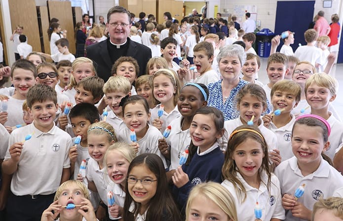 Students of St. Jude the Apostle School, Atlanta, were treated to cherry, lime and raspberry âBomb Popsâ on Sept. 30, the day their school was recognized as a National Blue Ribbon School for 2014. Standing among the students are St. Jude the Apostle Church pastor, Msgr. Joe Corbett, background left, and school principal Patty Childs, background right. Blessed Trinity High School, Roswell, and Pinecrest Academy, Cumming, were the two other Catholic schools in the state to receive similar recognition from the U.S. Department of Education. Photo By Michael Alexander