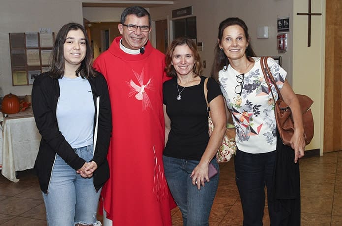 Father João Gualberto Ribeiro da Silva, second from left, poses for a photo with (l-r) Jodie Enes, her mother Veronica and Rejani Bogo before the celebration of his Sept. 26 farewell Mass at Holy Family Church, Marietta. Photo By Michael Alexander