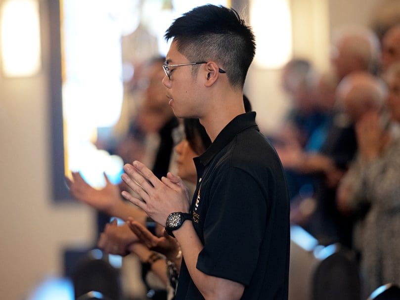 Seminarian Quinton Tran prays during the General Intercessions during the Candidacy Mass held at Christ the Redeemer Church on July 27, 2022. Tran was one of eight seminarians who became a candidate for orders. Photo by Johnathon Kelso
