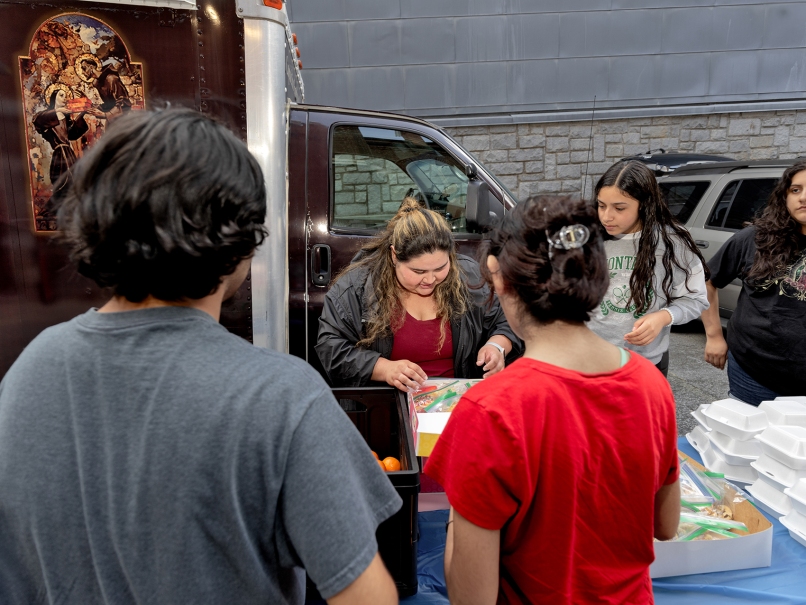 Volunteer Monica Gonzaelz, center, prepares food boxes for people outside the food truck at the Shrine of the Immaculate Conception. Photo by Johnathon Kelso