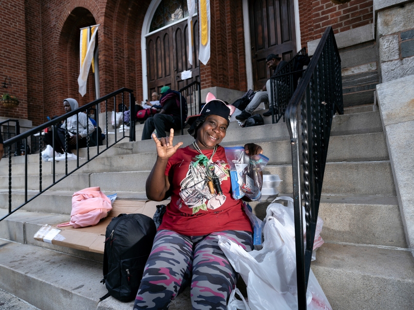 A woman holds a bag of hygiene products and snacks recieved from the volunteers of the Capuchin food truck ministry outside the Shrine of the Immaculate Conception. Photo by Johnathon Kelso