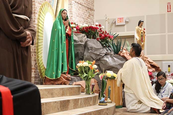 Juan Diego, played by Adrian Vargas, kneels before Our Lady of Guadalupe, played by Anahi Calderon, during a presentation at Divino Niño Jesús Mission, Duluth, about the apparition of the Virgin Mary on Tepeyac Hill, just outside Mexico City. Photo By Michael Alexander
