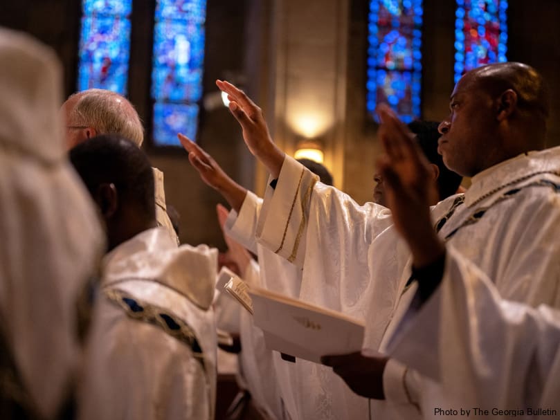 Priests pray during the eucharistic liturgy of the Chrism Mass held at Cathedral of Christ the King. Priests renew their vows during the annual Mass. Photo by Johnathon Kelso