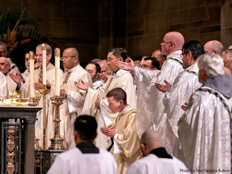 Priests pray together during the annual Chrism Mass held the Tuesday of Holy Week at the Cathedral of Christ the King. Photo by Johnathon Kelso