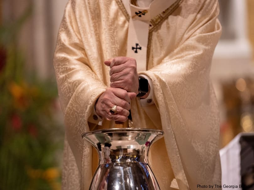 Archbishop Gregory J. Hartmayer, OFM Conv., mixes the oil during the consecration of the chrism at Cathedral of Christ the King. Photo by Johnathon Kelso